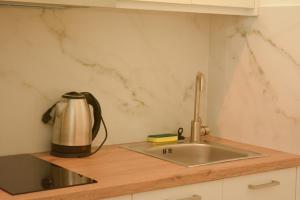 a kitchen with a sink and a kettle on a counter at Venetia in Tsoutsouros