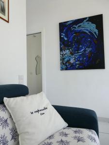 a blue couch with a pillow in front of a painting at Capresella luxury apartment in Capri +27 photos