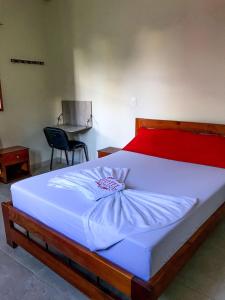 a bedroom with a large white bed with a red headboard at Hotel Diamante in Saravena