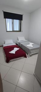 a bedroom with two beds and a red blanket at Apartamento vila velha in Vila Velha
