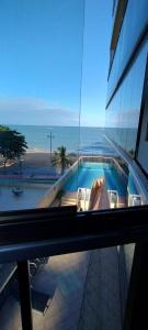 a view of a building with a swimming pool and the ocean at Apartamento vila velha in Vila Velha