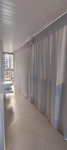 a hallway with a white curtain in a building at Apartamento vila velha in Vila Velha