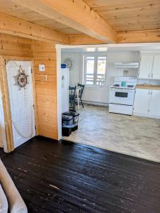 a kitchen with white appliances and a wooden ceiling at Legges Hill Loft in Twillingate +11 photos
