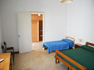 Zimmer mit 2 Betten, einem Tisch und einer Tür in der Unterkunft Holiday home SORA with air conditioning in Torre dellOrso in Torre dell'Orso