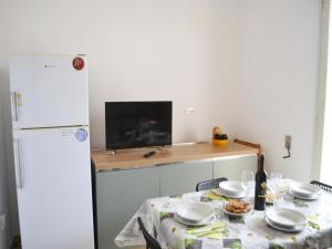 eine Küche mit einem Tisch und einem weißen Kühlschrank in der Unterkunft Holiday home SORA with air conditioning in Torre dellOrso in Torre dell'Orso + 14 Fotos