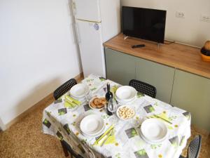 einen Tisch mit einem Tischtuch mit Tellern und Lebensmitteln darauf in der Unterkunft Holiday home SORA with air conditioning in Torre dellOrso in Torre dell'Orso