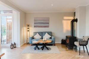 a living room with a blue couch and a table at Lütt Diekje in Westermarkelsdorf