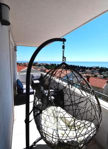 a wire basket on a balcony with a view at Dubrovnik Icy Guest House in Dubrovnik