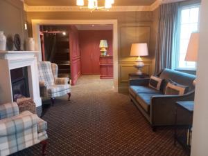 a living room with a couch and chairs and a fireplace at Castle Lodge in Killarney
