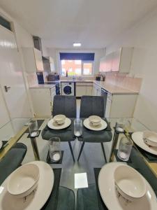 a room with a table and chairs with plates and glasses at 3 Bedroom Northenden Home by City SuperHost in Wythenshawe