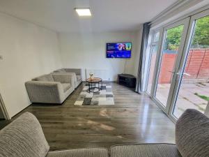 a living room with two couches and a tv at 3 Bedroom Northenden Home by City SuperHost in Wythenshawe