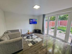 a living room with a couch and a sliding glass door at 3 Bedroom Northenden Home by City SuperHost in Wythenshawe
