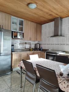 a kitchen with a table with chairs and a refrigerator at Sitio Julimari in Itabirito
