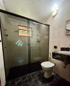 a bathroom with a shower and a toilet and a sink at Sitio Julimari in Itabirito +10 photos