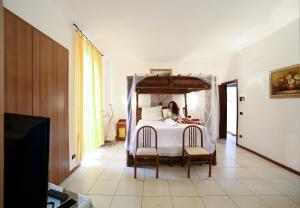 een vrouw op een bed in een slaapkamer bij Hotel Suisse in Bellagio