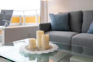 ein Wohnzimmer mit einem Tisch mit Kerzen darauf in der Unterkunft Strandhotel Scharbeutz Dünenliebe in Scharbeutz