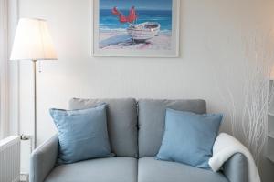 ein Wohnzimmer mit einer Couch und einem Bild an der Wand in der Unterkunft Strandhotel Scharbeutz Dünenliebe in Scharbeutz