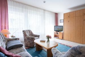 Una sala de estar con dos sofás y un televisor. en Waldstraße 2 Wohnung 12, en Kellenhusen