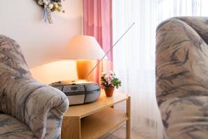 Una sala de estar con dos sillas y una mesa con teléfono. en Waldstraße 2 Wohnung 12, en Kellenhusen