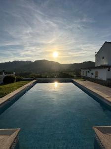 ロンダにあるVilla Catalinaの日没の背景にスイミングプール