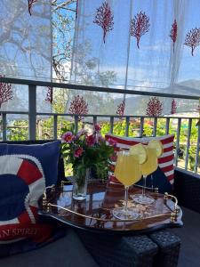 a tray with two drinks on a table in front of a window at Elisabeth Seaview Apartments Sorrento Coast in Vico Equense +9 photos