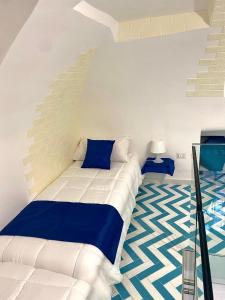 a bedroom with a bed with blue and white at La Casa del Capitano in Amalfi