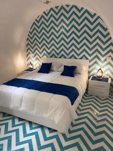 a bedroom with a large bed with a checkered wall at La Casa del Capitano in Amalfi