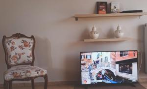 a tv sitting in a living room with a chair at Rosemary apartment in Eretria