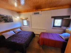 a bedroom with two beds in a room at Cal Sicull in Santa María de Marlés +9 photos