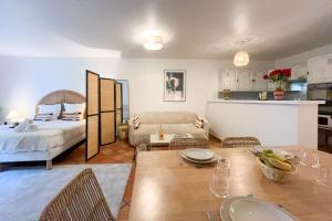 a living room with a bed and a dining table at Place des Lices - NK in Saint-Tropez
