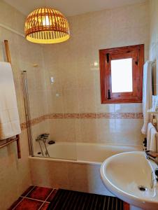 ein Badezimmer mit Badewanne und Waschbecken in der Unterkunft Casa rural para 4 personas, 2 dormitorios y terraza sombreada - El Cortijo Escondido, La Uva in Ohanes