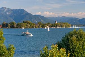 a boat on a large lake with sailboats at Wohnung Weitsicht Ruhpolding, 3 Schlafzimmer, Bergpanorama, Alleinlage in Ruhpolding