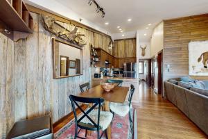 a kitchen and living room with a wooden wall at Snowmass Village 95 in Snowmass Village