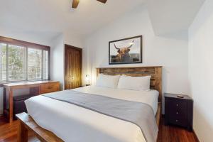 a bedroom with a bed with a cow picture on the wall at Snowmass Village 95 in Snowmass Village