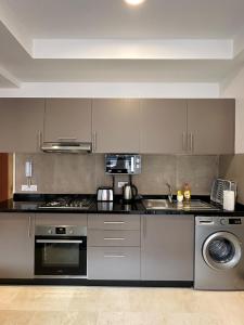 una cocina con estufa y fregadero en Noria Golf Poolside Garden Flat, en Marrakech