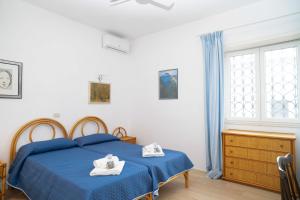 a bedroom with a blue bed with towels on it at Villa vintage a 100m dal mare, relax a Terracina in Terracina