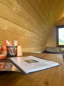 a book on a table in a tiny house at Reservoir View Glamping Pod in Dol-y-gaer Station