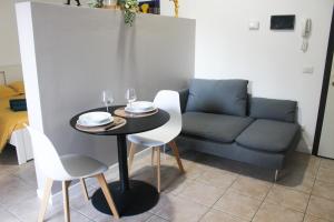 a table and chairs and a couch in a room at La Suite dell'Artista SWIMMING POOL AND AIR CONDITIONING in Stresa