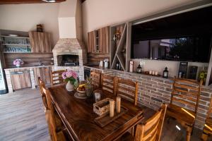 a kitchen with a wooden table and a fireplace at Villa Tia in Mostar