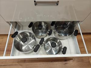 three bowls in a drawer of a stove at Portki - Cztery Pory Roku in Pszczeliny