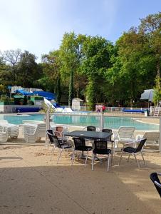 a table and chairs in front of a swimming pool at mobil home in La Celle-sous-Gouzon