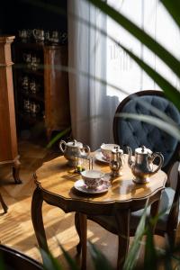 a wooden table with tea pots and plates on it at Palace Hotel in Viareggio
