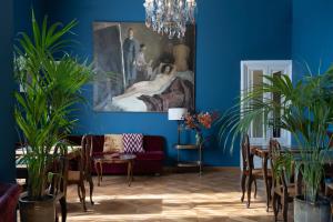 a blue living room with a painting and plants at Palace Hotel in Viareggio