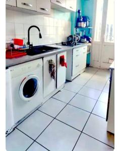 a kitchen with a sink and a washing machine at Chambre privée Anglet quartier Quintaou in Anglet
