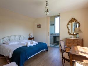 a bedroom with a bed and a table and a mirror at Maison Bretonne Madame est Servie 4 in Perros-Guirec
