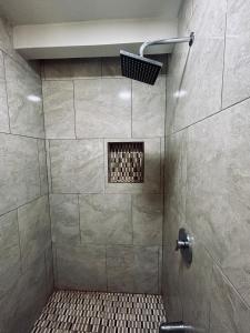 a bathroom with a shower with a tiled floor at Stellar Cottage W Amazing Views On Hummingbird Hwy in Alta Vista +4 photos