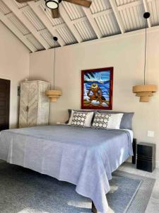 a bedroom with a large bed with a blue blanket at Holiday Time Le Reve Beach House & Casita in San Pedro