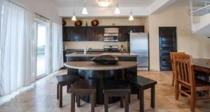 a kitchen with a table and chairs and a refrigerator at Waterfront 6 Br Villa W Private Plunge Pool in San Pedro