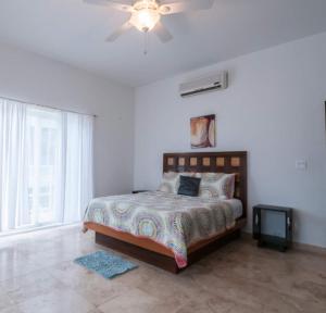 a bedroom with a bed and a ceiling fan at Waterfront 6 Br Villa W Private Plunge Pool in San Pedro +24 photos