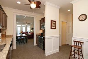 a kitchen and living room with a clock on the wall at Burpeau Unit A by Bryant Real Estate in Kure Beach +23 photos